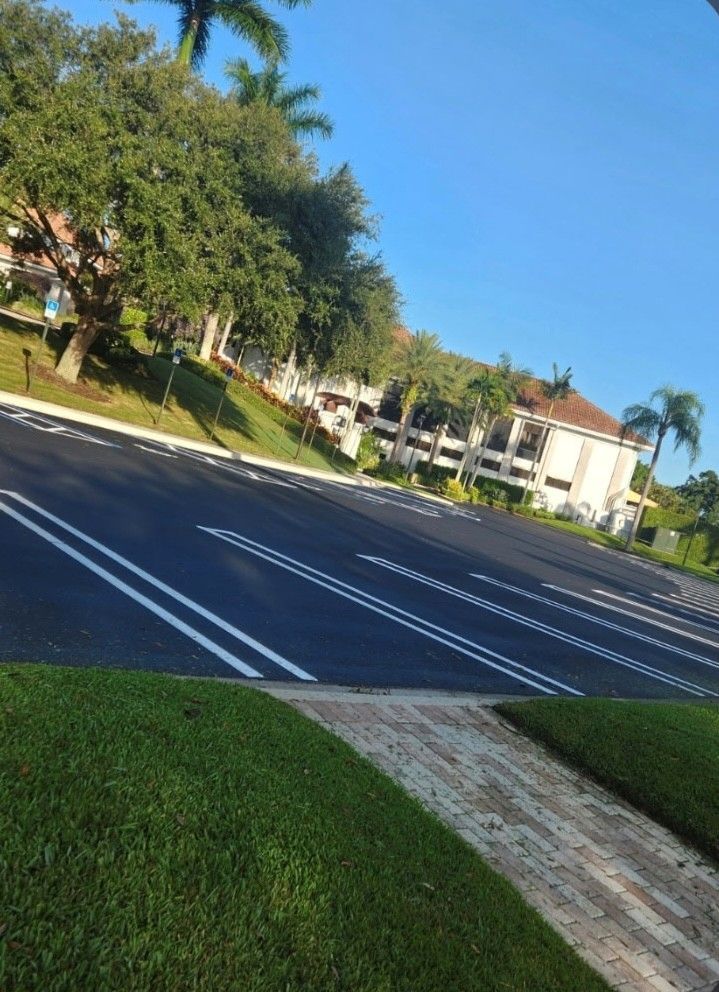 Tilting view of a quiet suburban street with trees, lawns, and apartment buildings under a blue sky