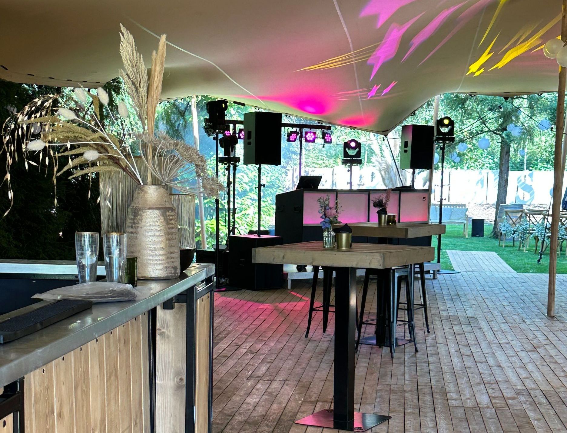 Een evenemententent voor buiten met een dj-booth, speakers 