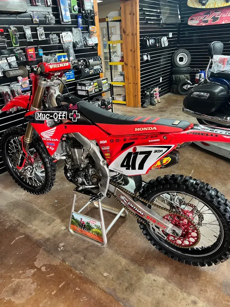 Red Honda dirt bike with number 417 on display in a motorcycle shop