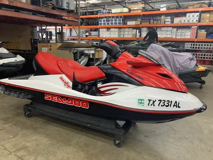 Red and white jet ski with TX 7331 AL in a warehouse garage area