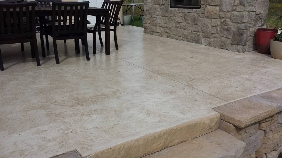 Stone and marble patio with dark seats and table — Cedar Rapids, IA — Earthworks Concrete