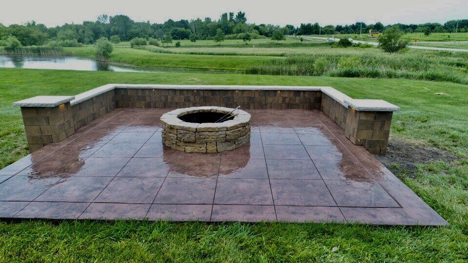 Circular fireplace on large open grassy area — Cedar Rapids, IA — Earthworks Concrete