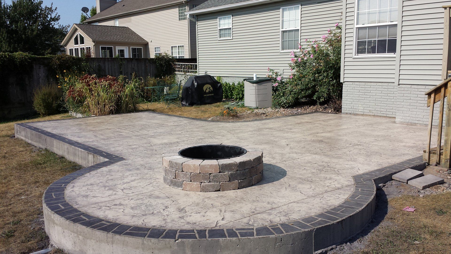 Open patio with circular fireplace in corner — Cedar Rapids, IA — Earthworks Concrete