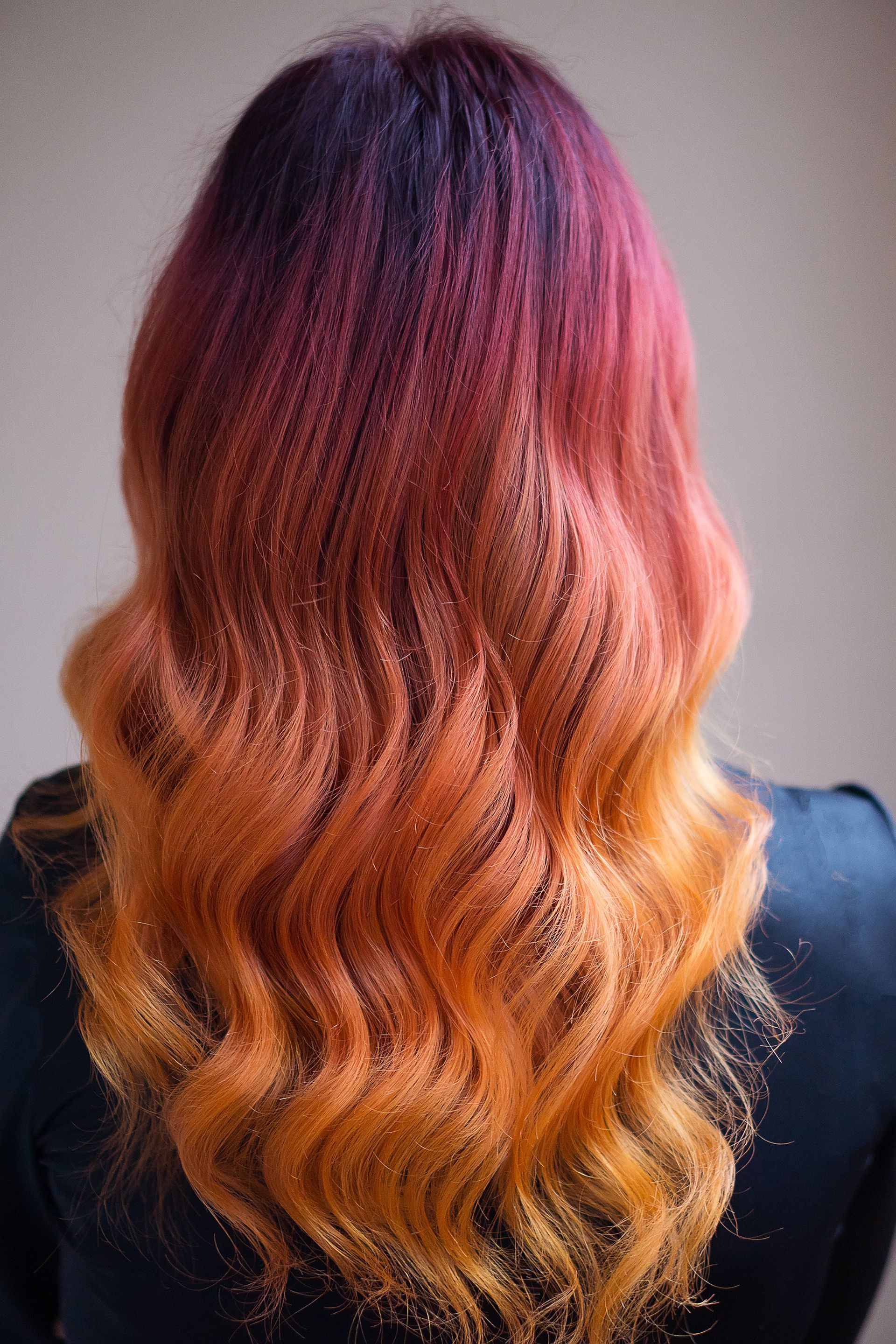 Back view of wavy hair dyed burgundy fading to copper and orange Back view of wavy hair dyed burgundy fading to copper and orange