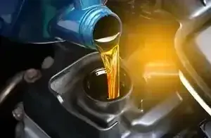Motor oil pouring from a blue bottle into an engine fill opening