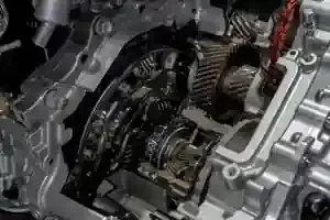 Close-up of a car engine’s internal transmission and gears, showing metallic mechanical components.