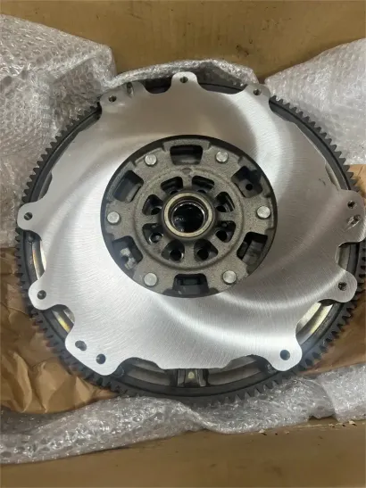 Hand holding a car clutch disc in front of a blurred automotive part background