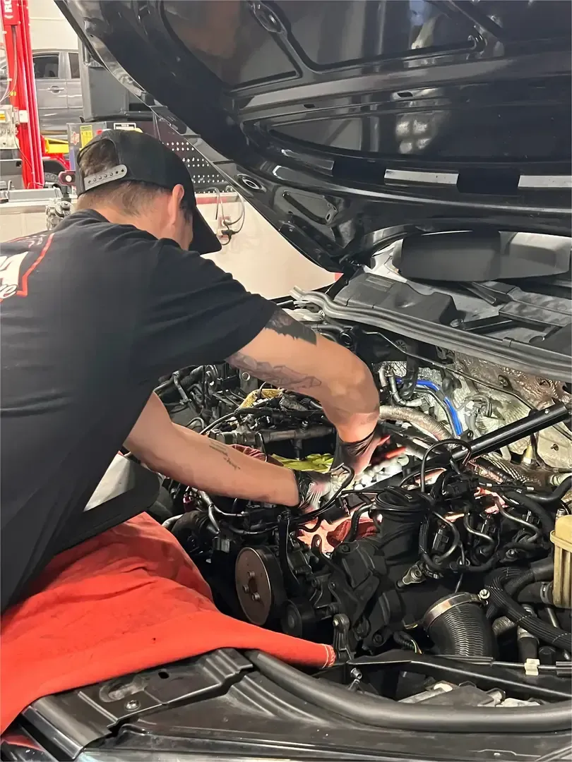 Mechanic in blue uniform using a tablet beside a van with digital car diagnostics overlay