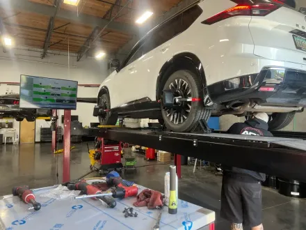 Mechanic tightening a car wheel with a wrench in an auto repair shop