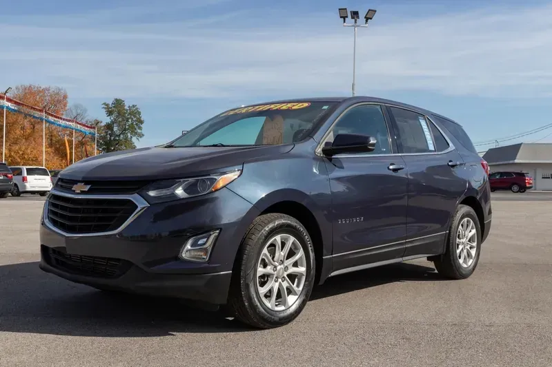 A dark blue Chevrolet Equinox SUV parked on an asphalt lot under a sunny sky.