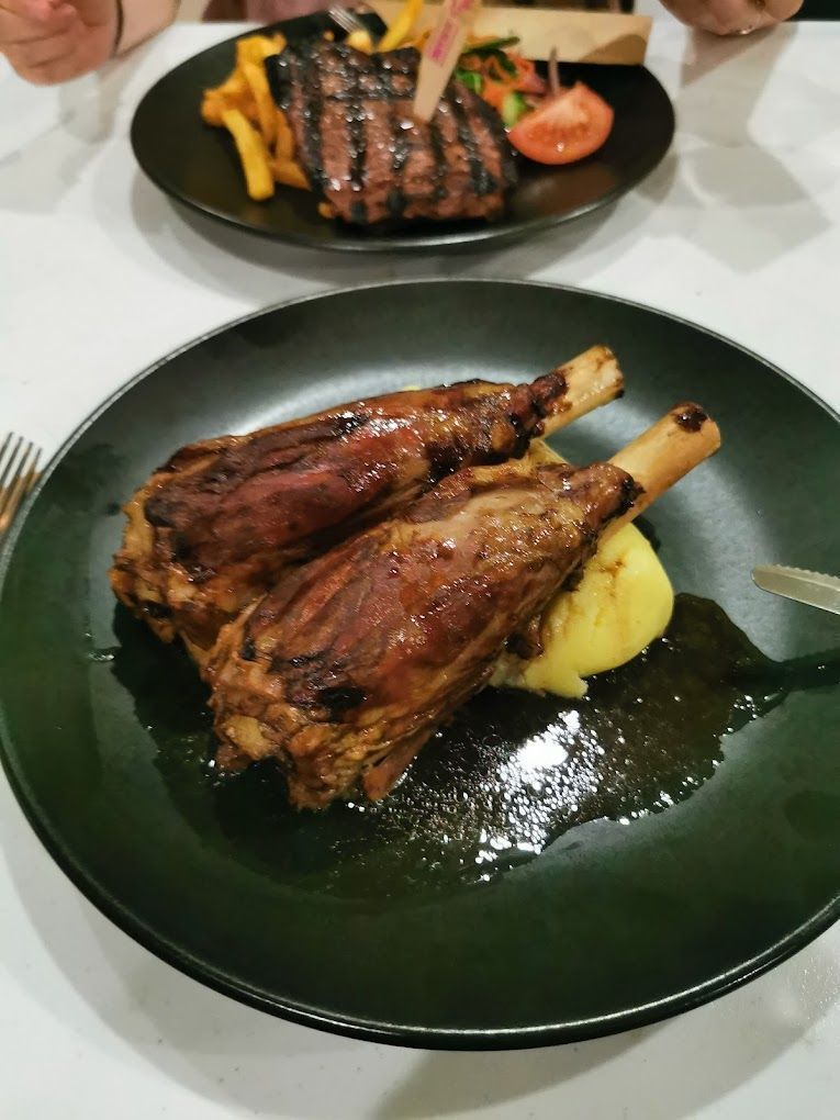 Two Braised Lamb Shanks on a Plate With Mashed Potatoes — Capricorn Tavern in Taranganba, QLD