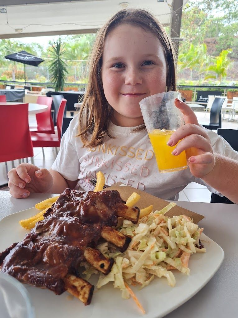 Girl Eating Ribs, Fries, and Coleslaw — Capricorn Tavern in Taranganba, QLD