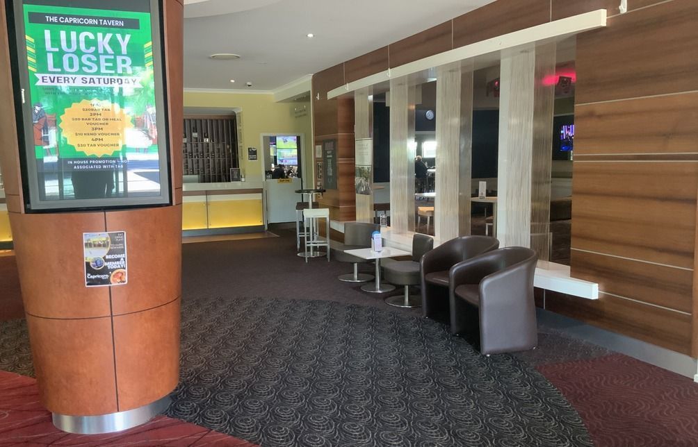 Lobby Area With a Digital Display, Seating, and a Reception Desk — Capricorn Tavern in Taranganba, QLD