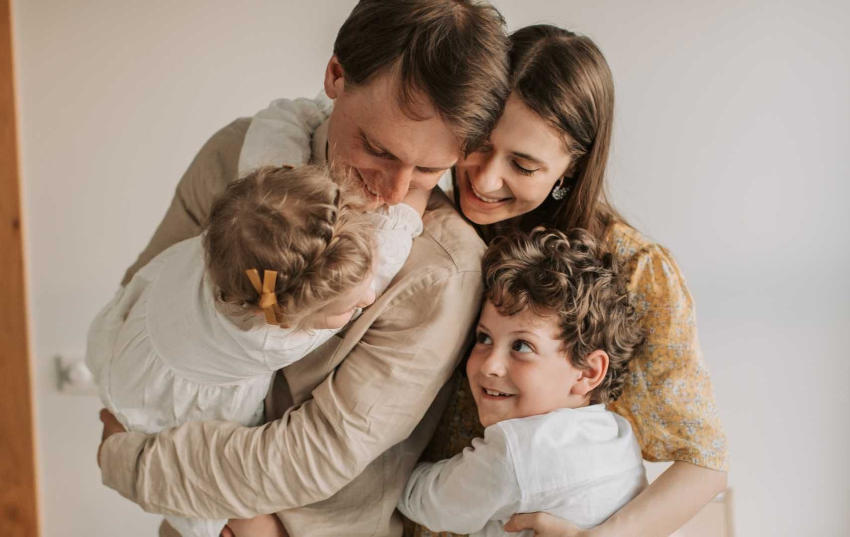 A family is standing next to each other and hugging each other.