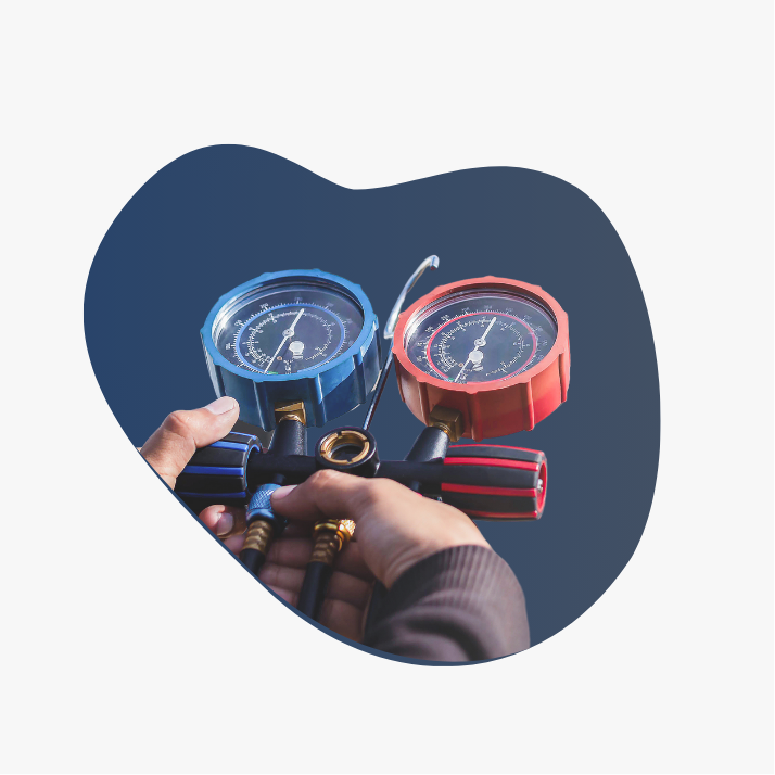 A person is holding a pressure gauge in their hand.