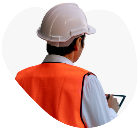 Worker in a white hard hat and orange safety vest using a tablet.