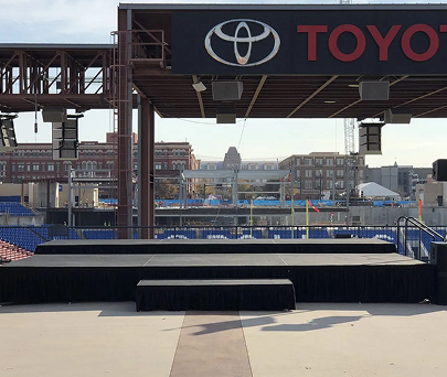 Empty outdoor stage with Toyota sign overlooking a stadium seating area