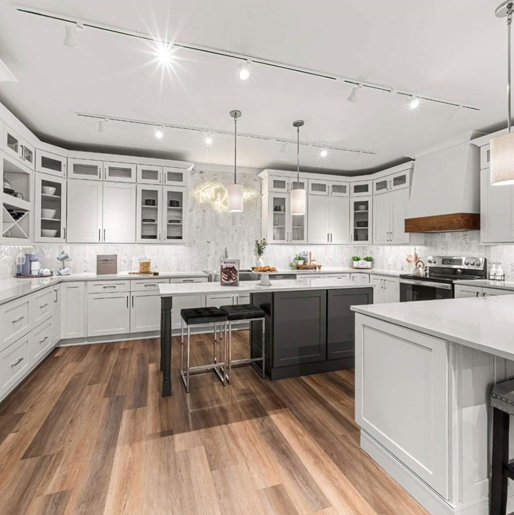 Bright white and gray modern kitchen with wood floors, island, and cabinetry.