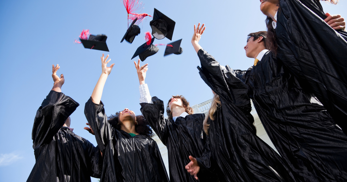 A group of graduates are throwing their caps in the air.