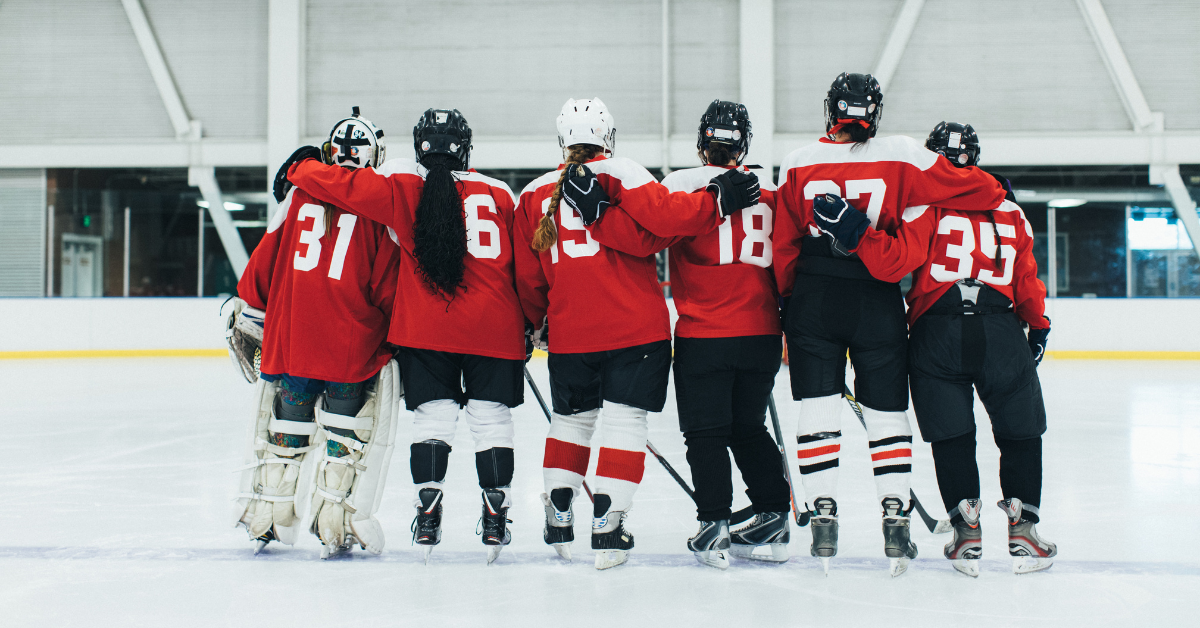A group of hockey players are posing for a picture on the ice.