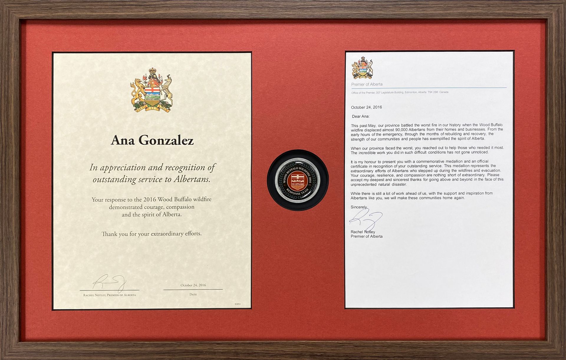 A framed letter and a certificate are in a wooden frame