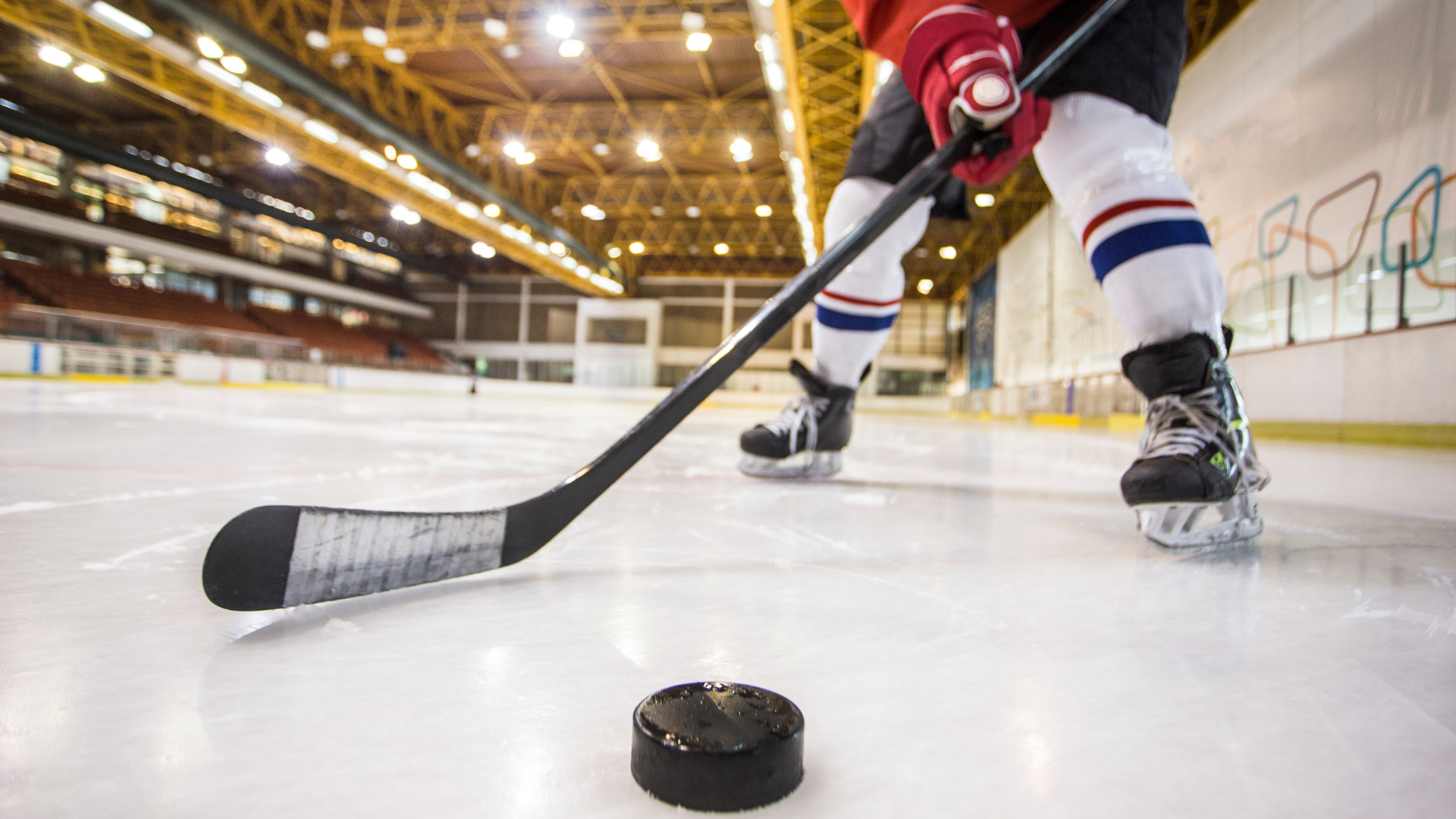 A hockey player is getting ready to hit the puck with his stick.
