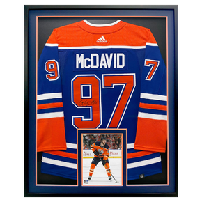 Framed Edmonton Oilers Connor McDavid #97 orange jersey with a small action photo below