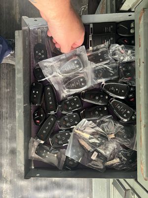 Hand placing a clear plastic controller case into a bin of black game controllers and accessories