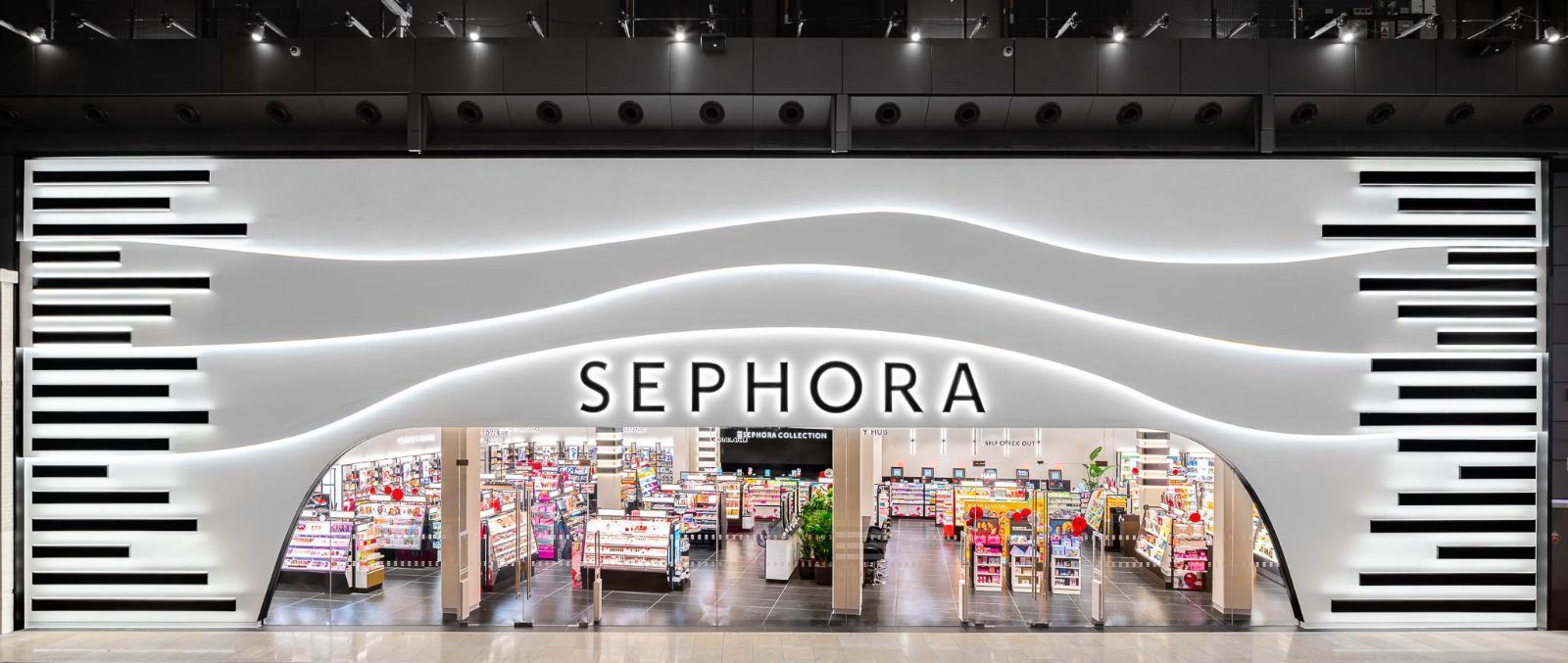 SEPHORA storefront with black-and-white wavy facade and illuminated entrance inside a mall