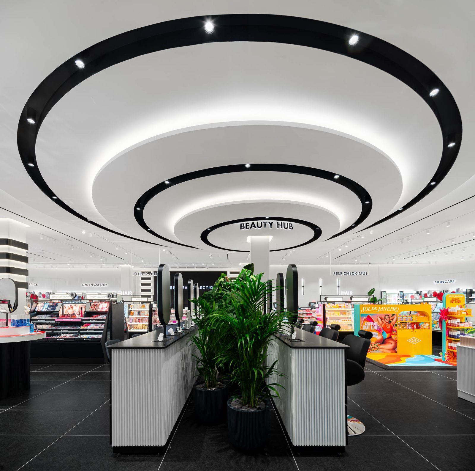 Modern retail checkout area with curved black-and-white ceiling lights and colorful displays