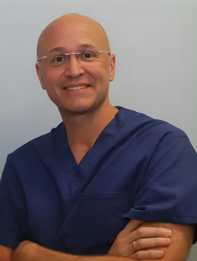A smiling doctor in a lab coat with a stethoscope around his neck.