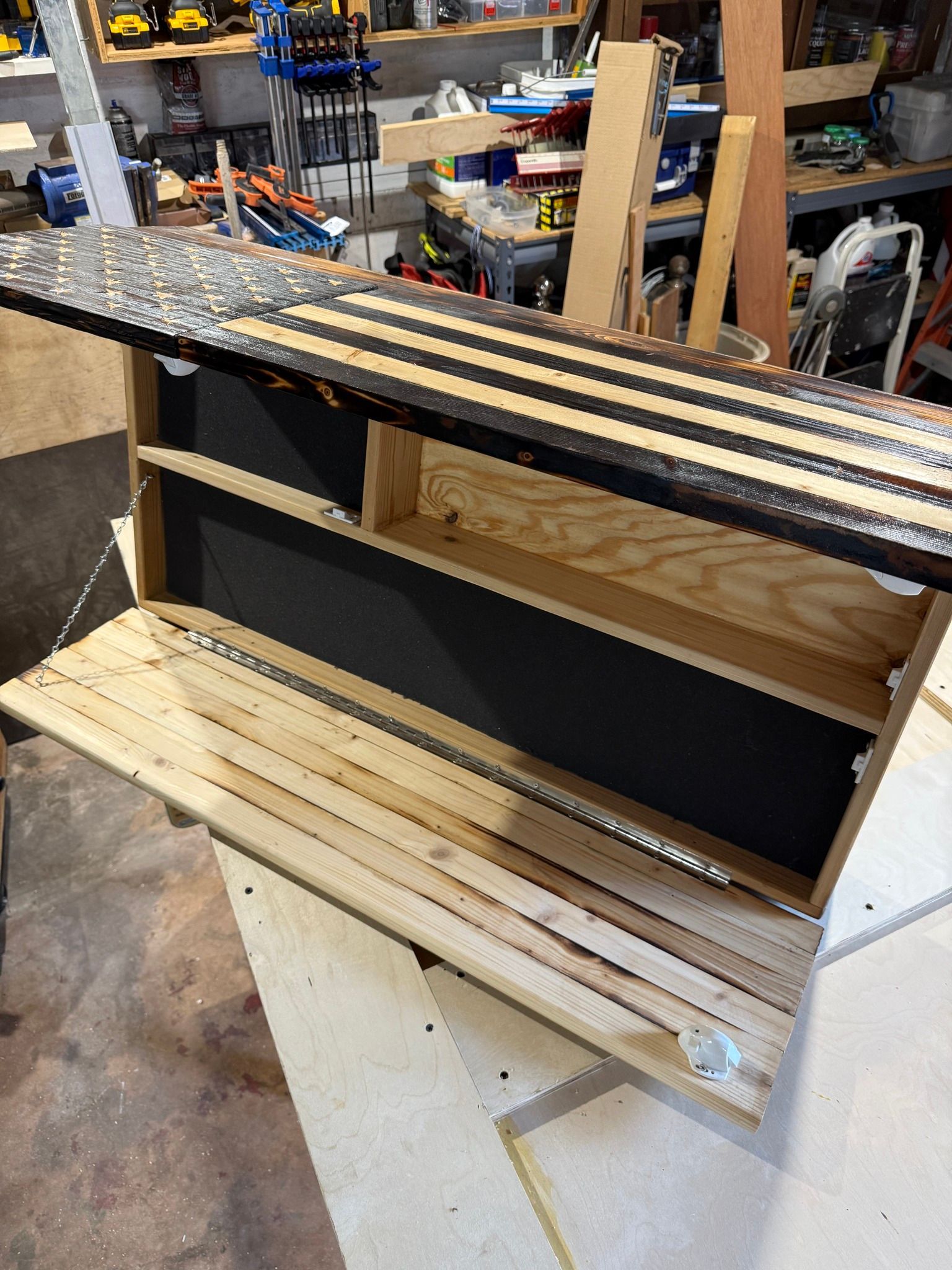 Partially assembled wooden cabinet with slatted shelves in a workshop garage