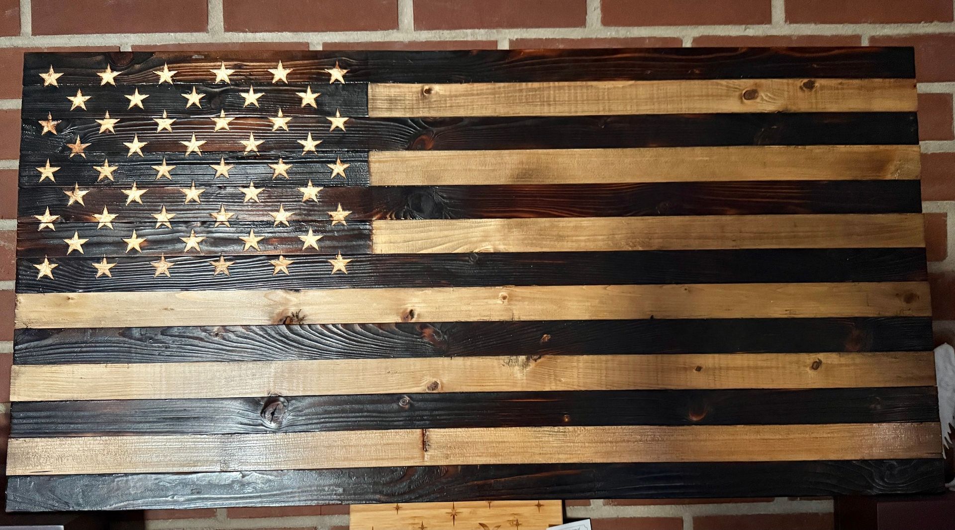 American flag-style wooden wall sign with blue stars and black-and-natural stripes