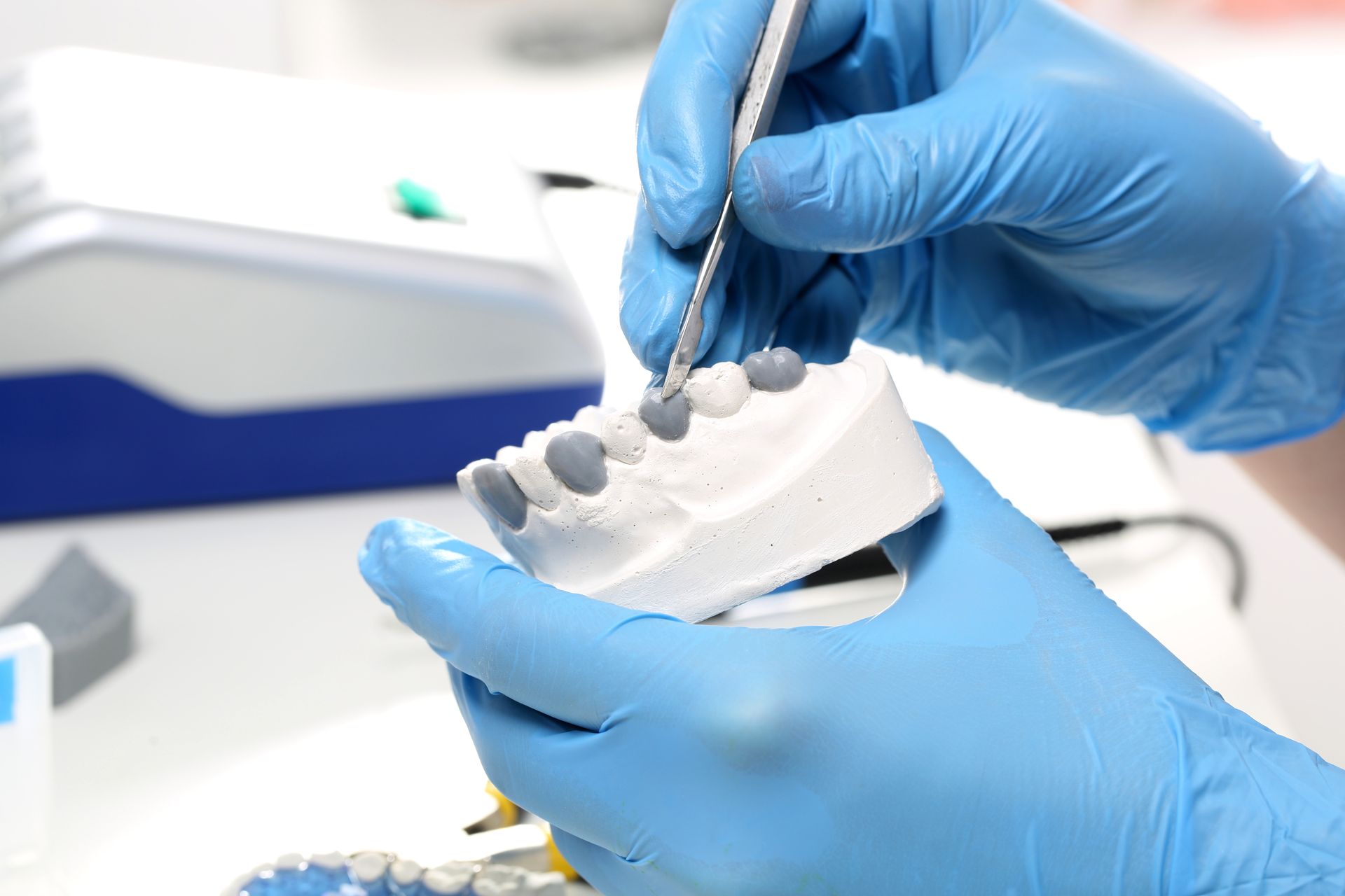 A dentist is working on a model of a person 's teeth.