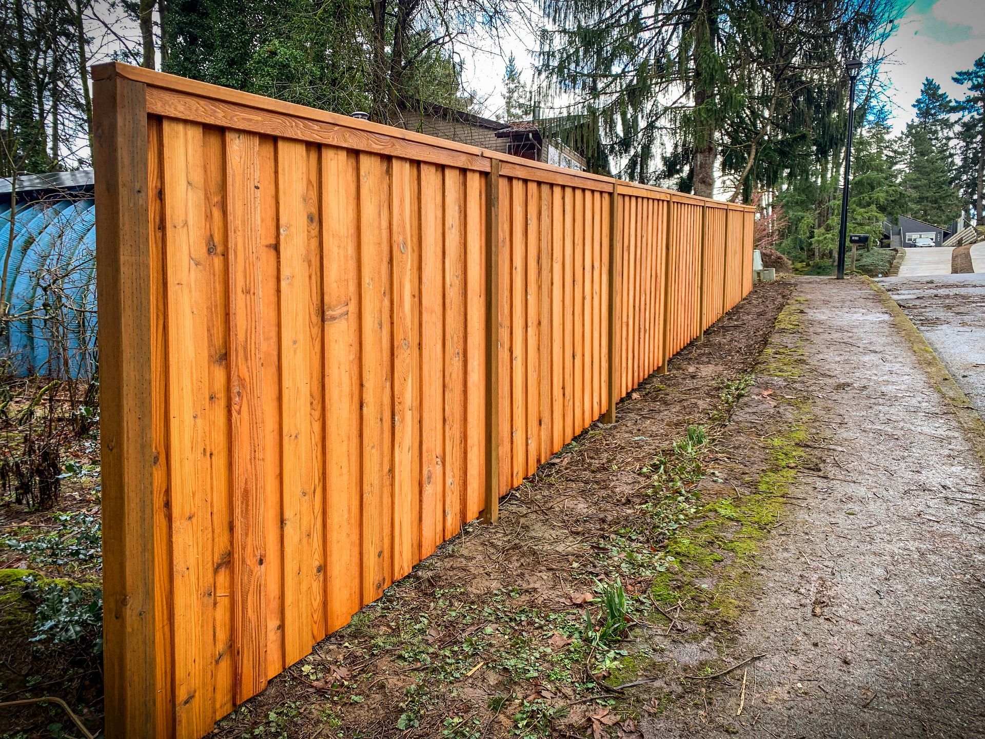 Black chain-link fence with a black top rail, viewed from a close, angled perspective, outdoors.