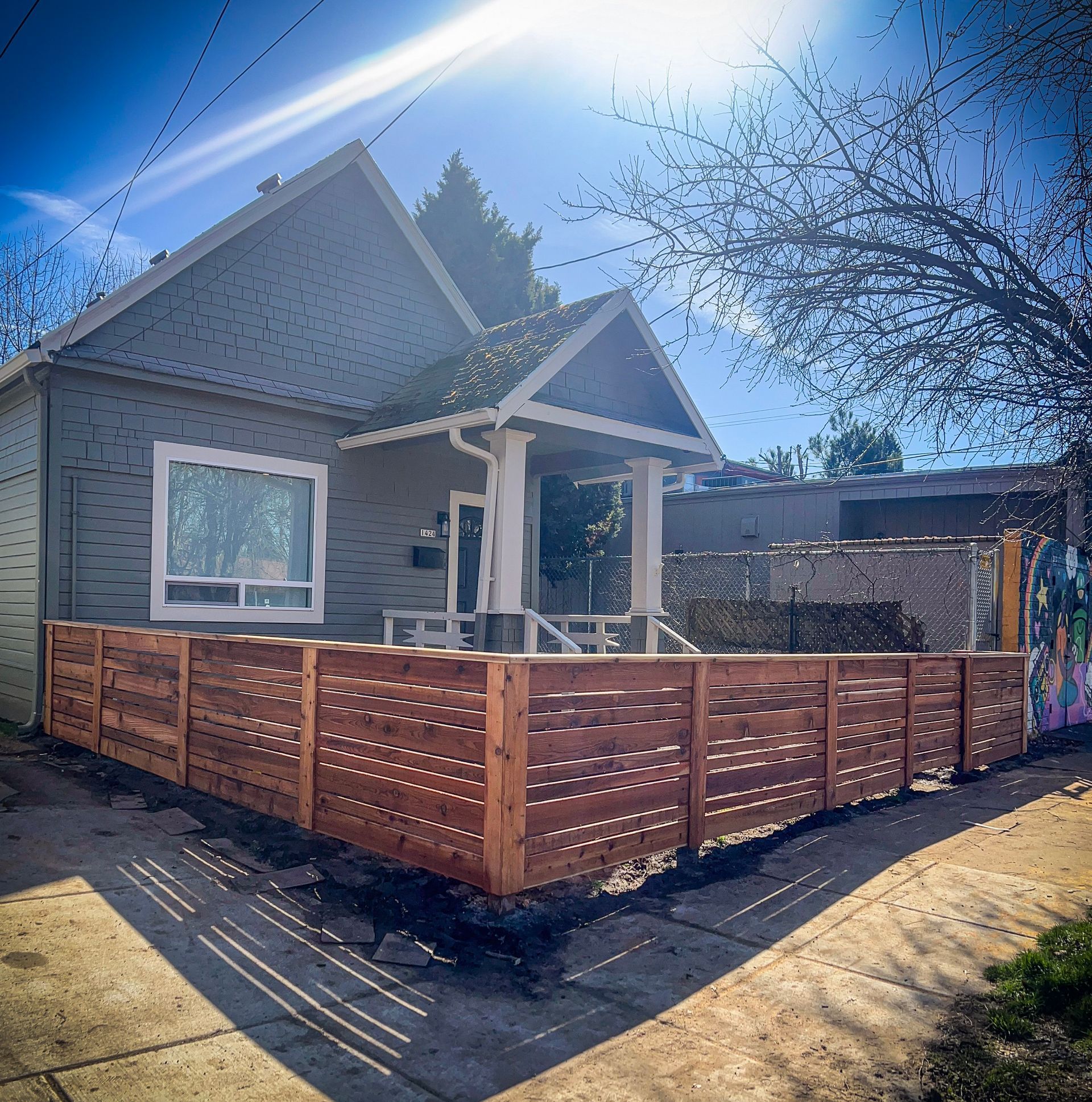 Black chain-link fence with a black top rail, viewed from a close, angled perspective, outdoors.
