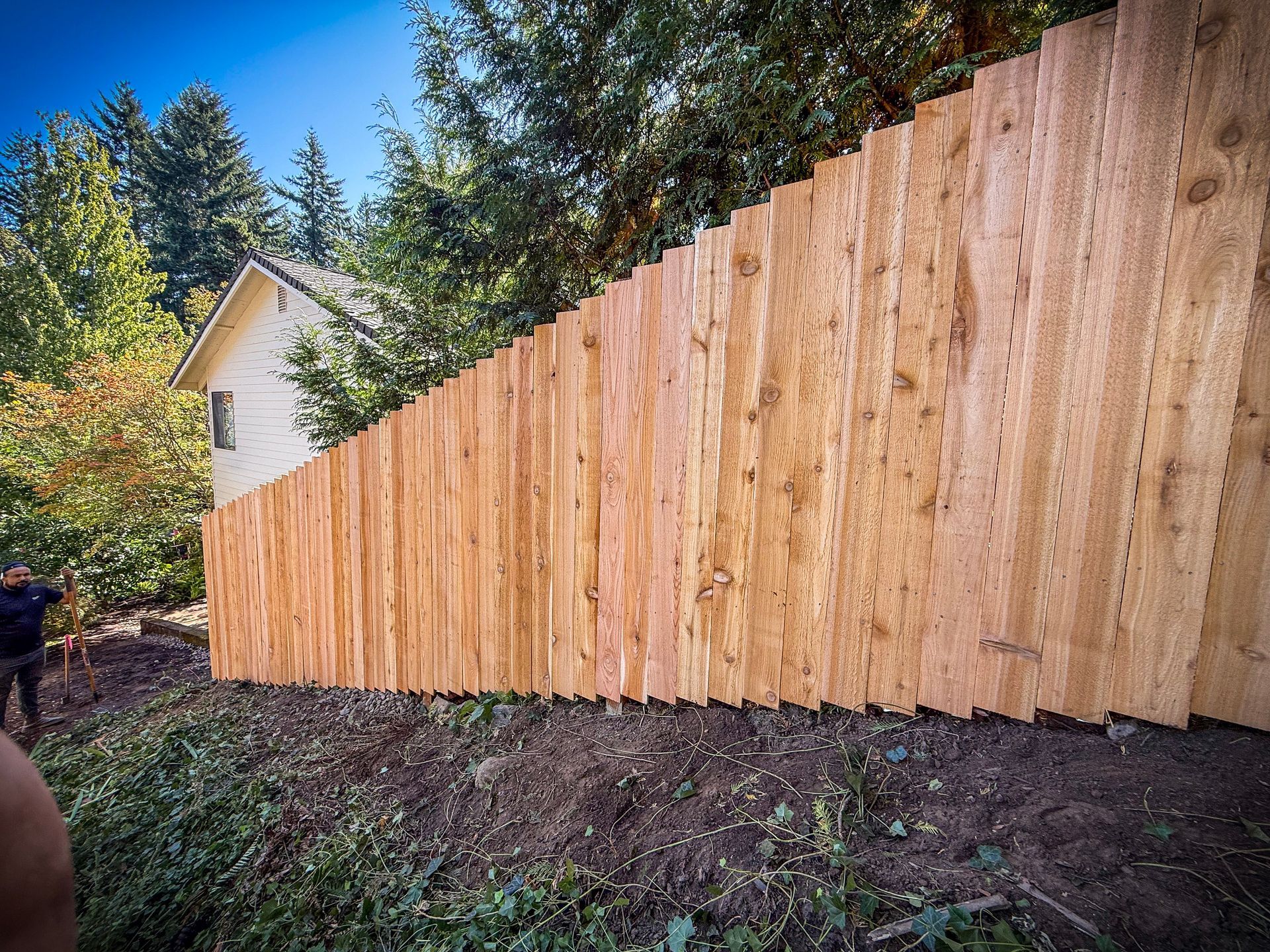 Black chain-link fence with a black top rail, viewed from a close, angled perspective, outdoors.
