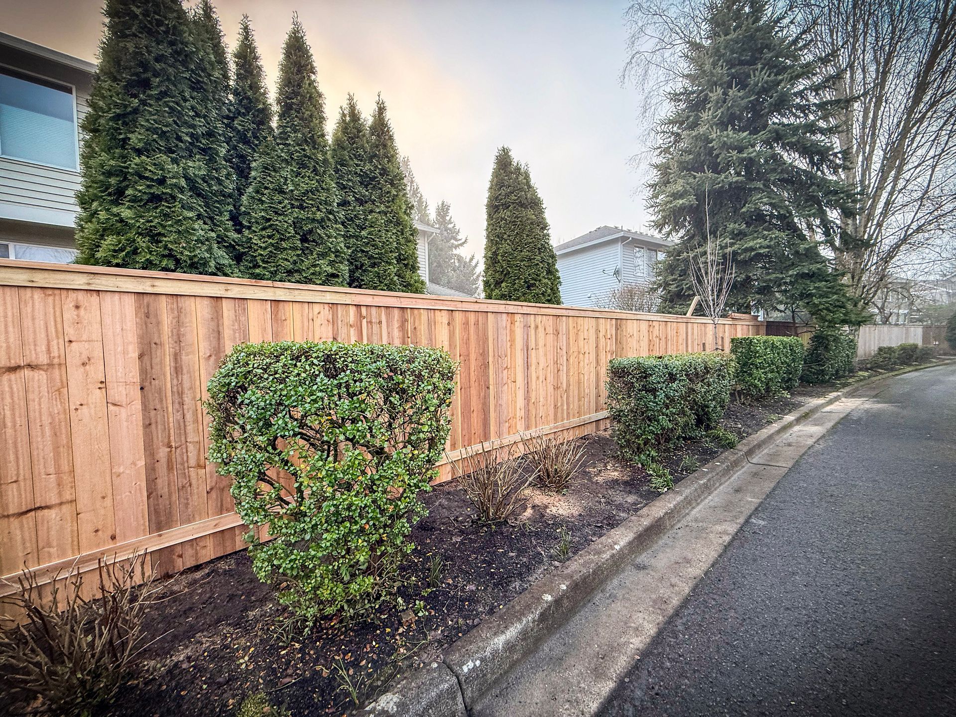 Black chain-link fence with a black top rail, viewed from a close, angled perspective, outdoors.