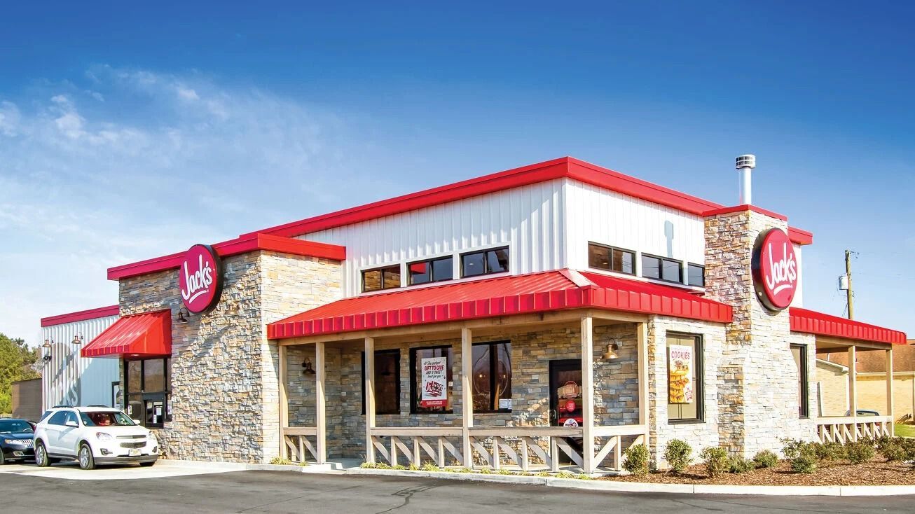 Jack's restaurant building with stone exterior, red roof and trim, and multiple windows; blue sky.