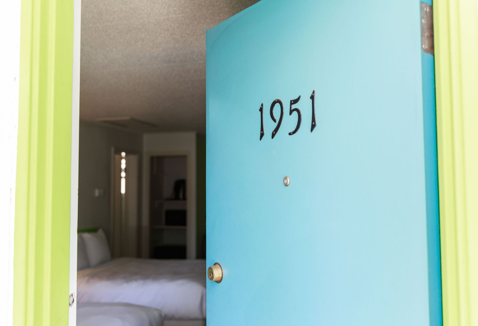 Light blue hotel room door labeled 