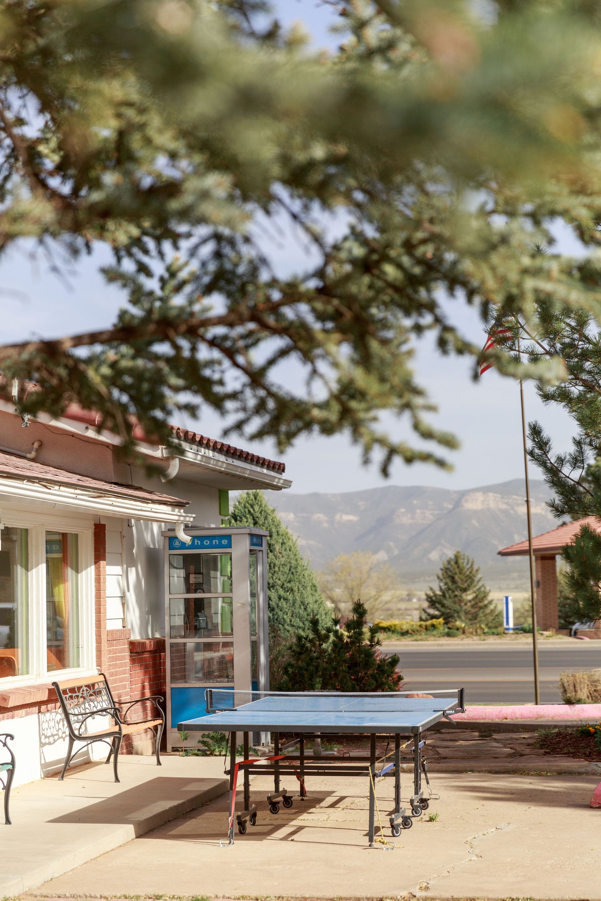 Ping pong table in front of The Retro Inn with a mountain backdrop. A tree is in the foreground.