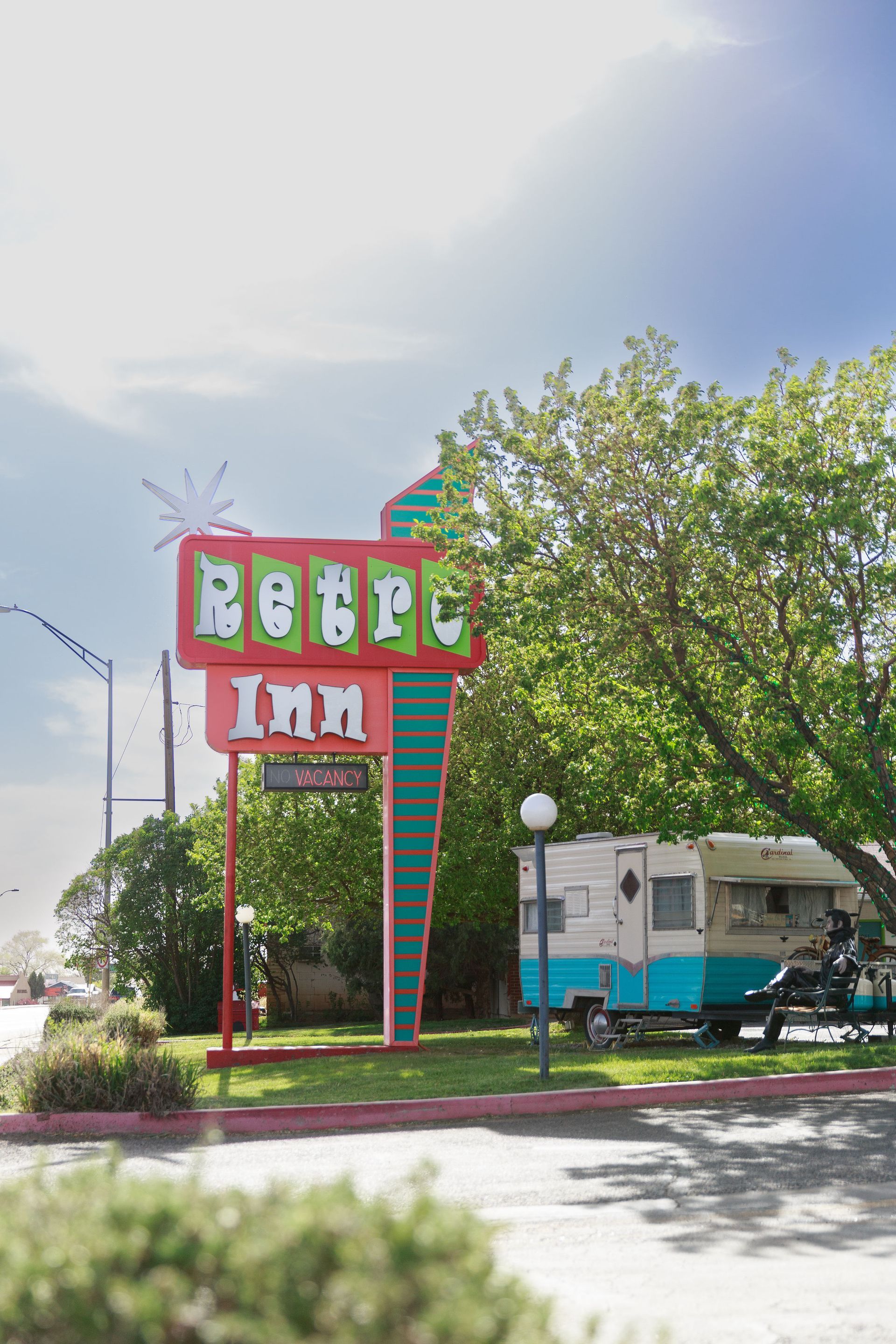 Retro Inn sign with a teal and white camper trailer parked in front.