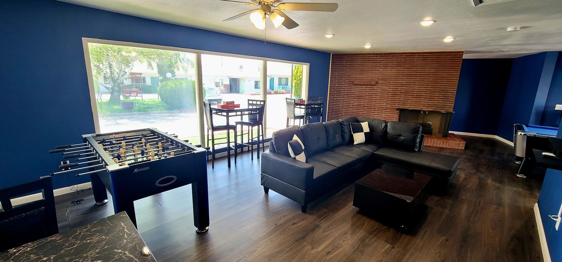 Retro Inn Game room with leather sectional, foosball table, pool table and  table and chairs. 