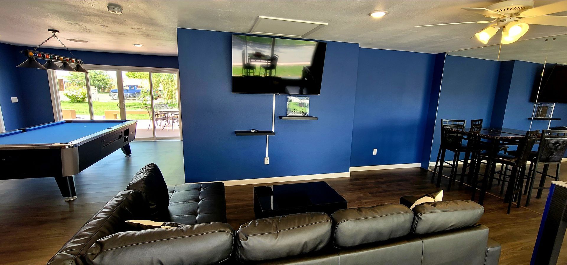 Retro Inn Game room with leather sectional, foosball table, pool table and  table and chairs. 