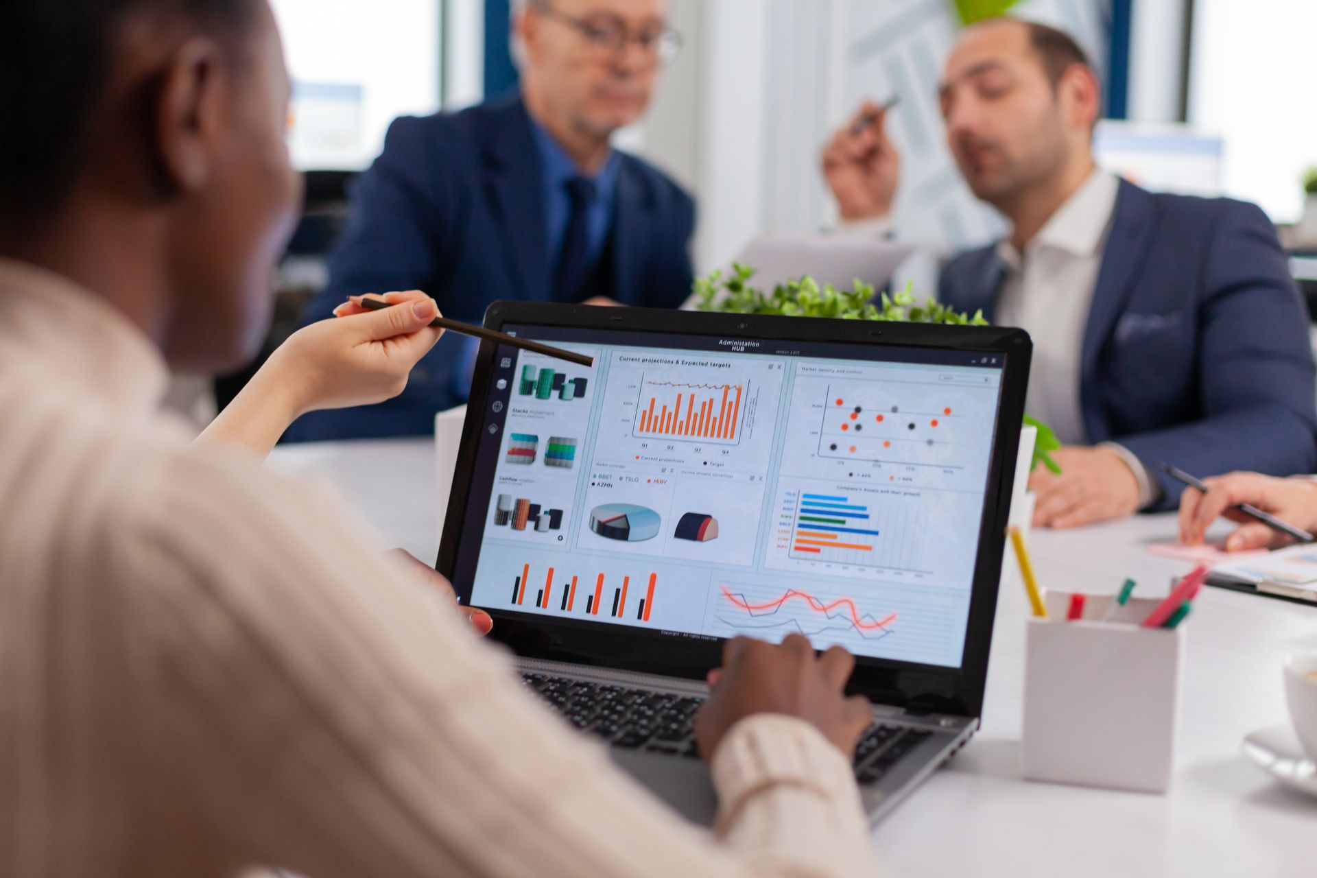 Team meeting with a laptop showing charts and dashboards in a bright office