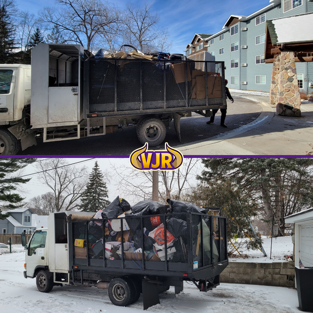 A truck filled with trash is parked in the snow next to a building.
