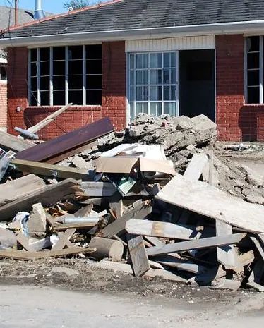 A pile of rubble in front of a brick house