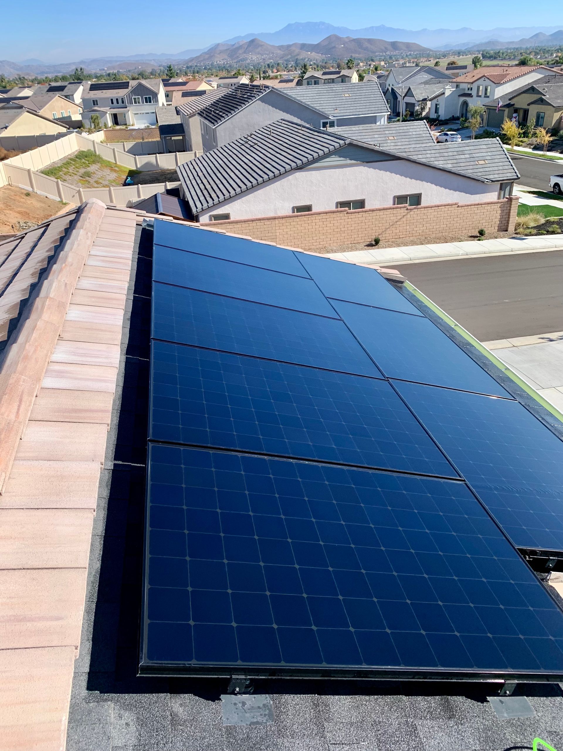 A row of solar panels on the roof of a house.