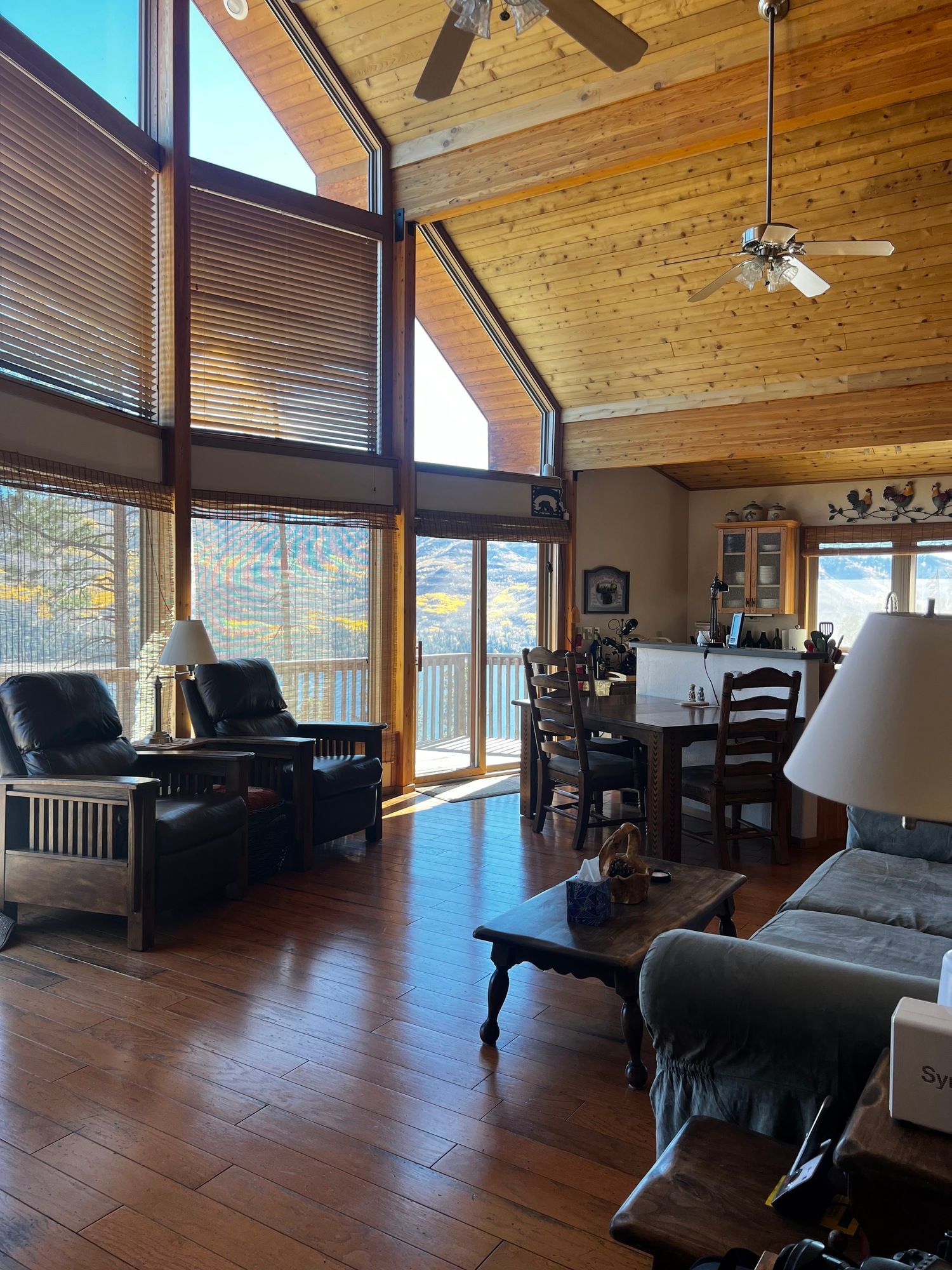 a living room with a lot of windows and a ceiling fan .
