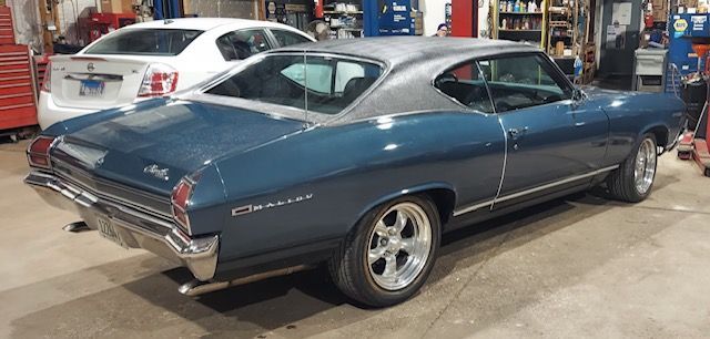Blue classic Chevrolet coupe parked in a garage, rear three-quarter view